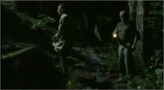  Locke walking with someone (Ben?), turns to shine his flashlight on someone o something...